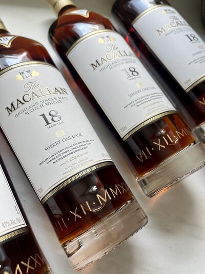 Bottles of Macallan scotch whisky hand engraved with roman numeral date.