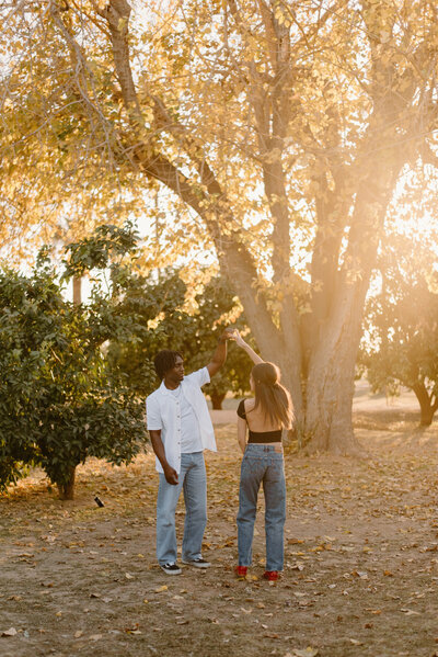 Couple dancing in Saguaro Ranch Park during golden hour