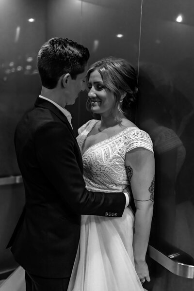 central ohio brides look lovingly at each other on elevator in classic black and white