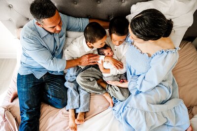 family in bed with a newborn boy  in home photography session