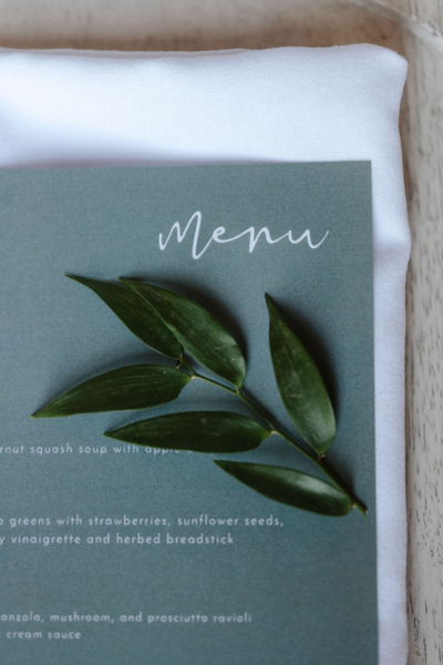Eucalyptus leaf placed a top a printed wedding meu