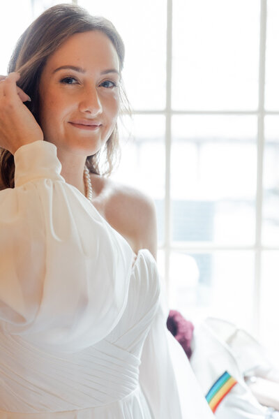 A photo of a bride fixing her hair before a wedding.