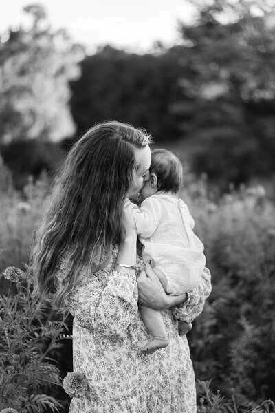 mom holding baby girl in garden asheville