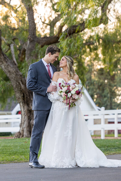 bride hugs her groom around the waist and smiles