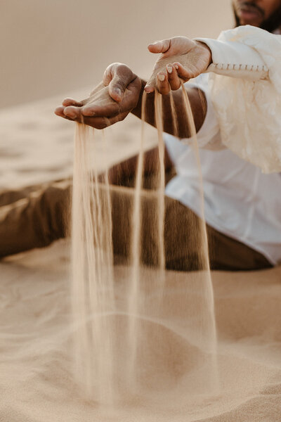 Bride and Groom play in the sand during their desert elopement.
