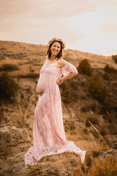 With the golden sunset of Medora area, a gorgeous momma embraces her baby bump during her outdoor maternity session.