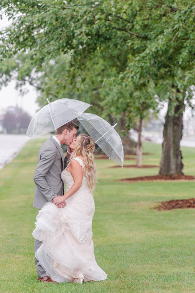 wedding couple in the rain with umbrellas in red deer alberta