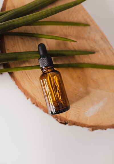 Essential oils self care products for moms laying on wooden table and greenery