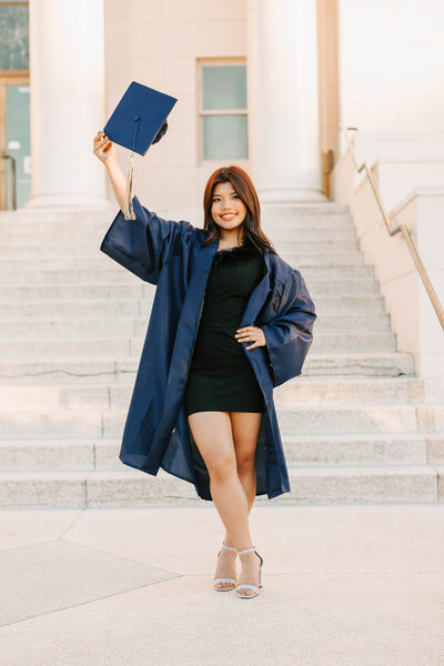 A senior girl in blue cap and gown stands in front of the courthouse in Albany, Oregon