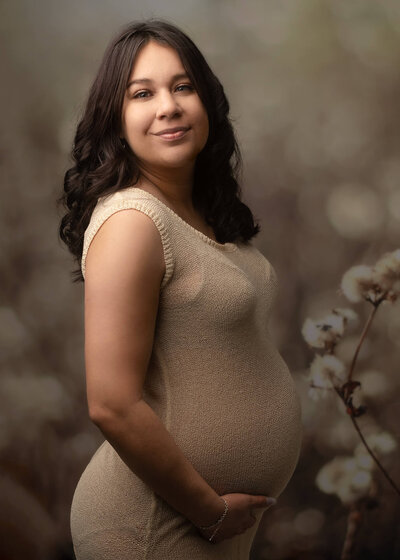 Newborn baby posed on bed with pink flowers