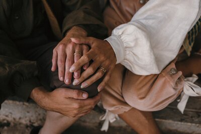 hands touching showing wedding rings of same sex couple 