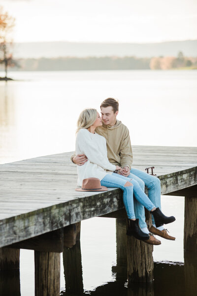 engaged couple sitting together on a dock in Chattanooga