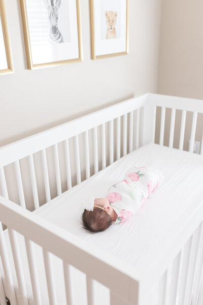Newborn swaddled in crib