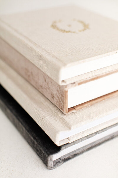 Stacked fine art photo albums in neutral colors, made of linen and velvet