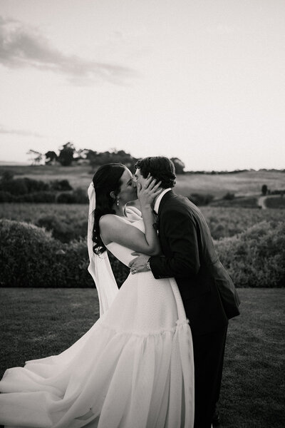 bride and groom share a kiss on wedding day