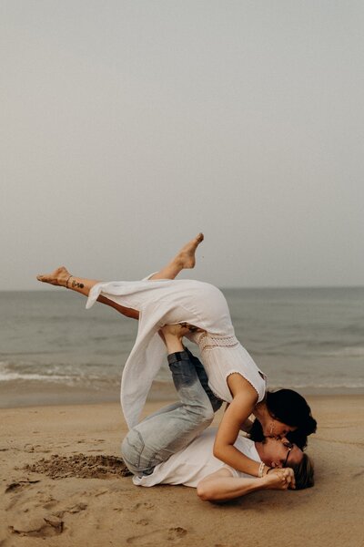 man and woman doing the airplane on beach