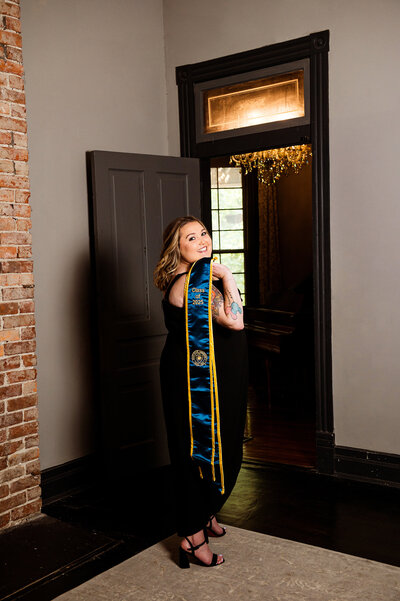 Online school graduate Nashville photoshoot inside historic home. Senior is holding her grad stole