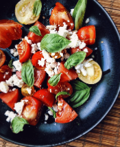 Farm to table meal topped with microgreen, tomatoes, and a bright green sauce