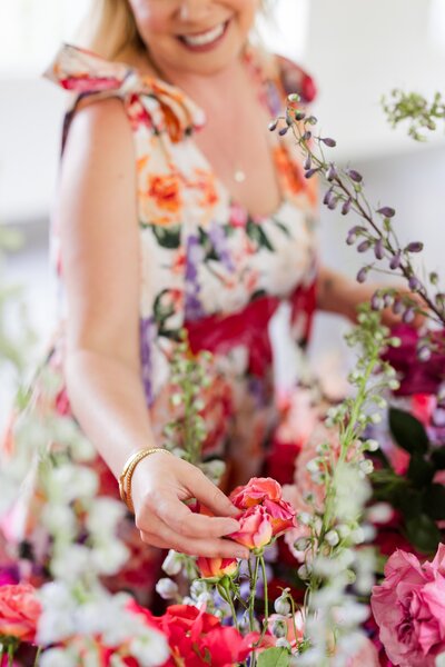 Floral designer curating vibrant blooms for a bold wedding florist installation in Austin, showcasing creative event styling.