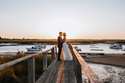 bride and groom kissing on a pier