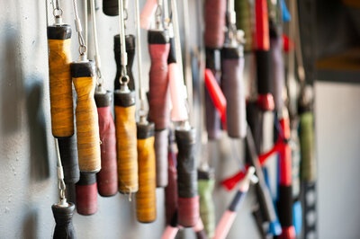 A row of jump ropes hanging on a wall.
