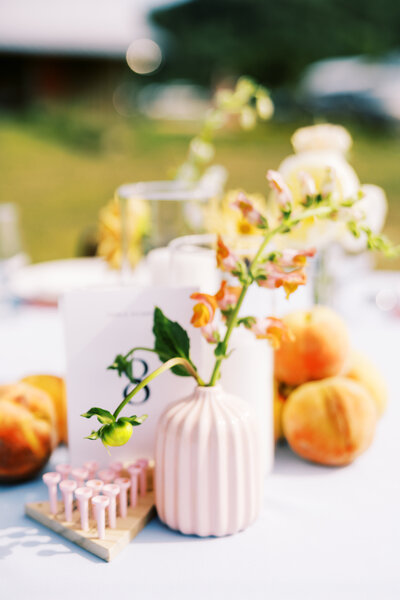 A detail of the reception decorations, including fresh fruit, games, and a bud vase designed by Moonlight Floral Co. photographed by My Sun and Stars Co.