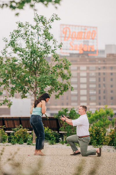 A proposal in downtown Baltimore in front of Domino Sugars sign, captured by local Baltimore proposal photographer.