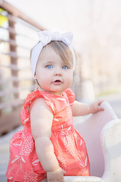 Stunning blue eyed toddler girl posed on a bridge for her 1 year milestone