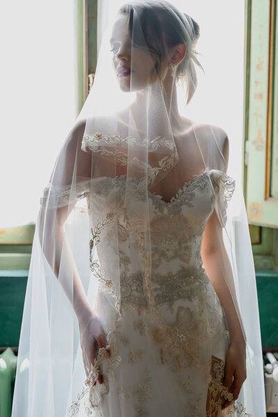 Bridal portrait by Feyer Photographer, a laced ivory bridal gown with a white veil