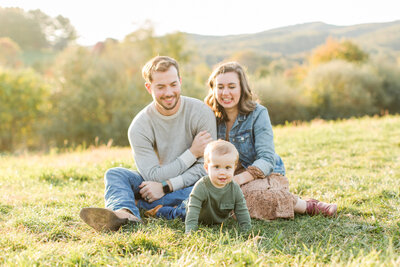family of three in a grass field