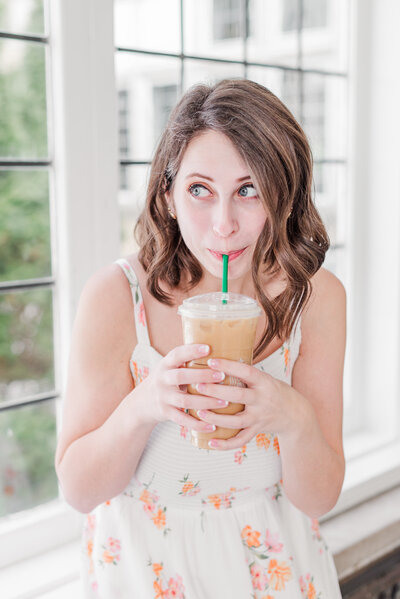 woman sipping iced coffee looking away from the cameraz