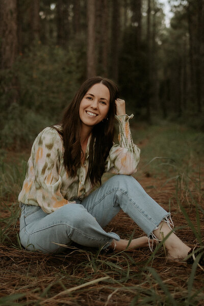 Kara smiling seated on the grass