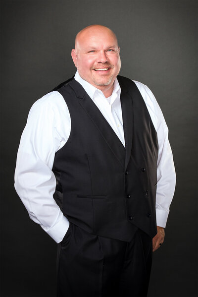 Brent, owner of IncredEvents, standing and smiling in wedding attire