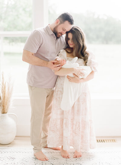 Mom smiling at her new baby while snuggling him during their newborn photography session in Raleigh NC. Photographed by newborn photographer Raleigh A.J. Dunlap Photography.