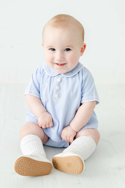 Baby sitting up smiling at the camera