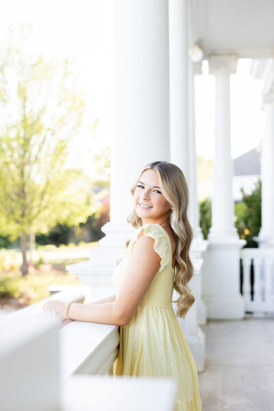 senior standing outside by white columns — Madison Abernathy Photo 