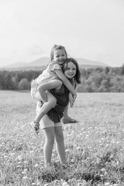 Daughter giving sister a piggyback | Family Photos Taken by Maine Photographer