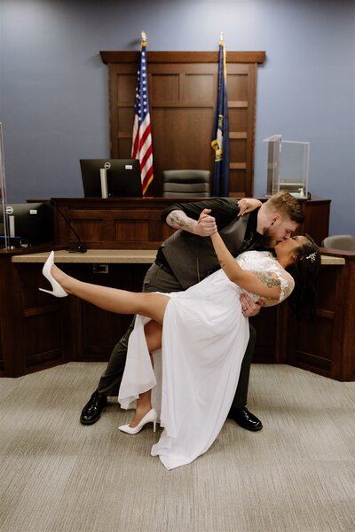 Groom dipping his bride for a kiss after their courthouse elopement in Omaha.