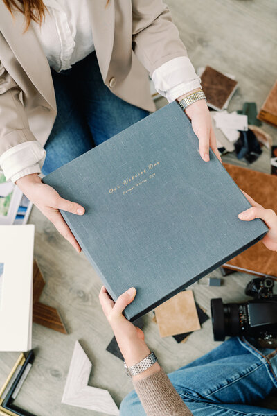 Woman passing a wedding album to bride