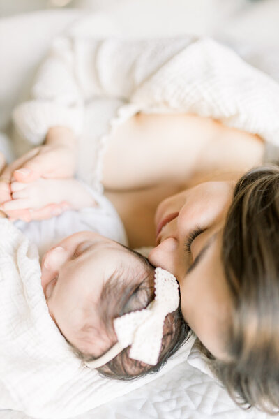 mama holding newborn baby in bed by ericka ana photography
