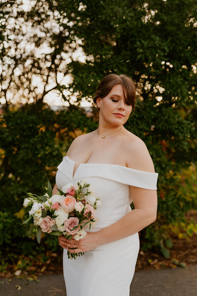 bride standing holding a flower bouquet
