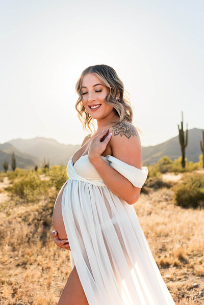 sweet, Arizona mom-to-be holding her maternity bump in elegant pose. 