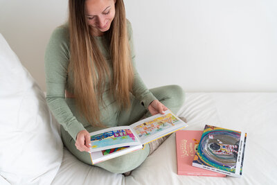 Femme en train de regarder un livre avec des dessins d'enfants