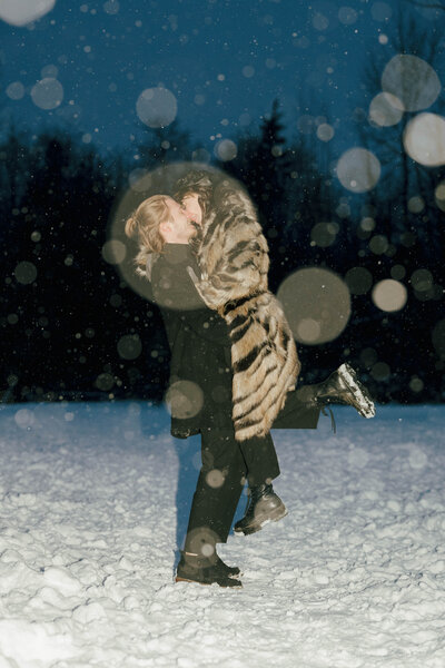 Couple embracing during a cozy winter engagement session in Vancouver, showcasing warmth and love