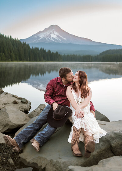 Couple snuggling on a rock at Trillium Lake in Mount Hood, Oregon.