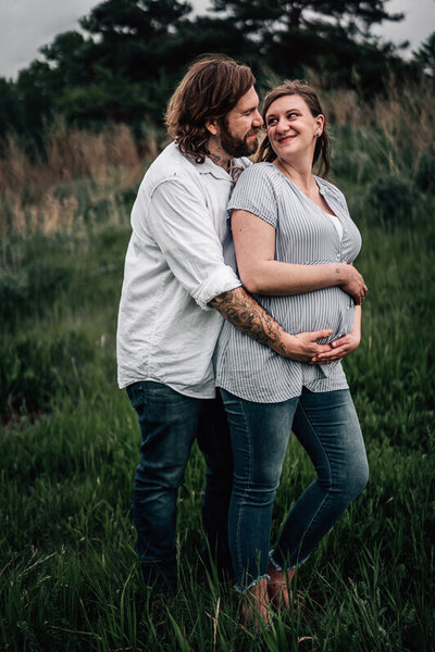 A pregnant mama smiles up at the camera during an in home lifestyle pregnancy photo shoot in Minneapolis.