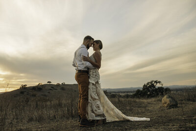 husband and wife embracing in the countryside