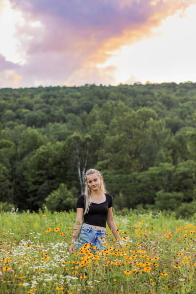 Photo of Senior standing in a field of flowers | Senior Session
