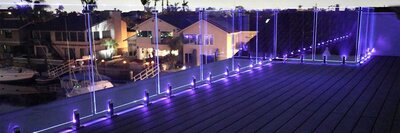 Glass railing from IG Railing at dusk with illuminated LEDs in purple. 