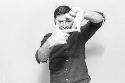 b&w image of guest posing against a white backdrop during a photo booth party entertainment
